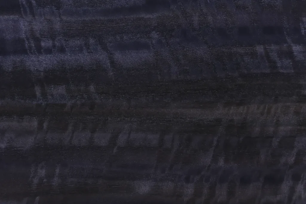 Fumed figured eucalyptus wood veneer quarter cut with pronounced wavy pattern and dark contrasting tones