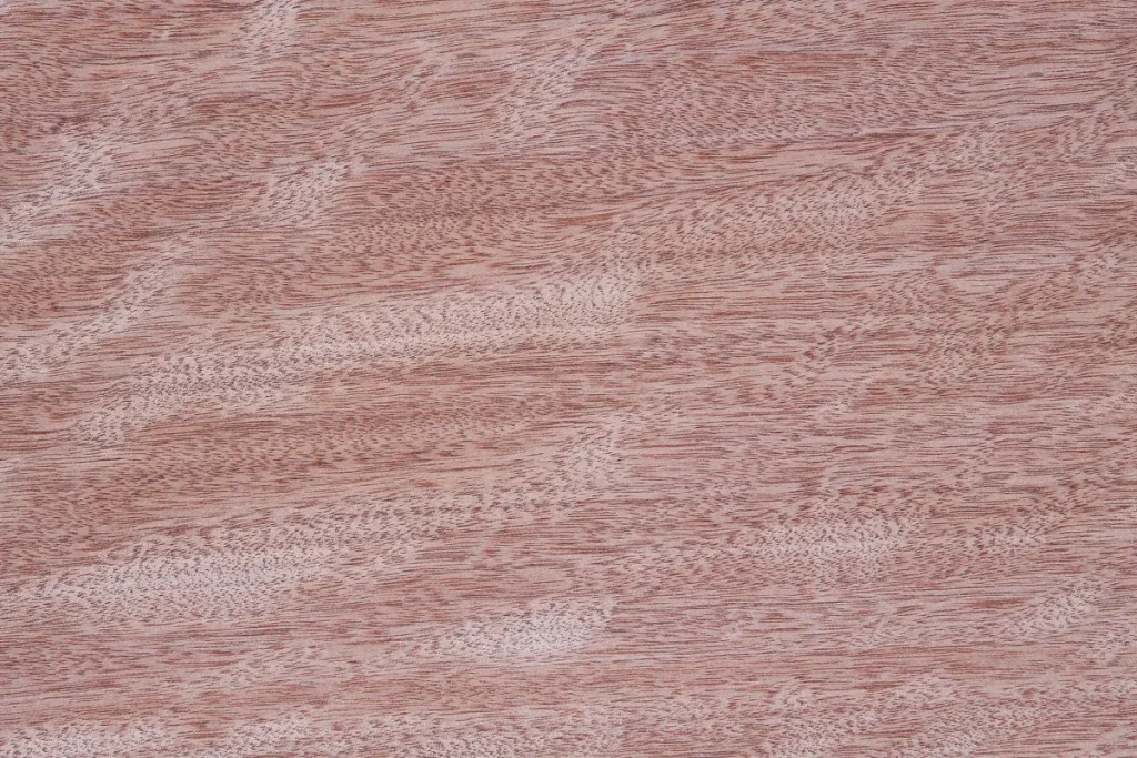 Placage de bois d’Okoumé figuré sur quartier, présentant un veinage ondé fin avec effet moiré et nuances rosées
